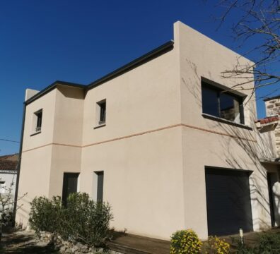 Maison beige clair et menuiserie noire