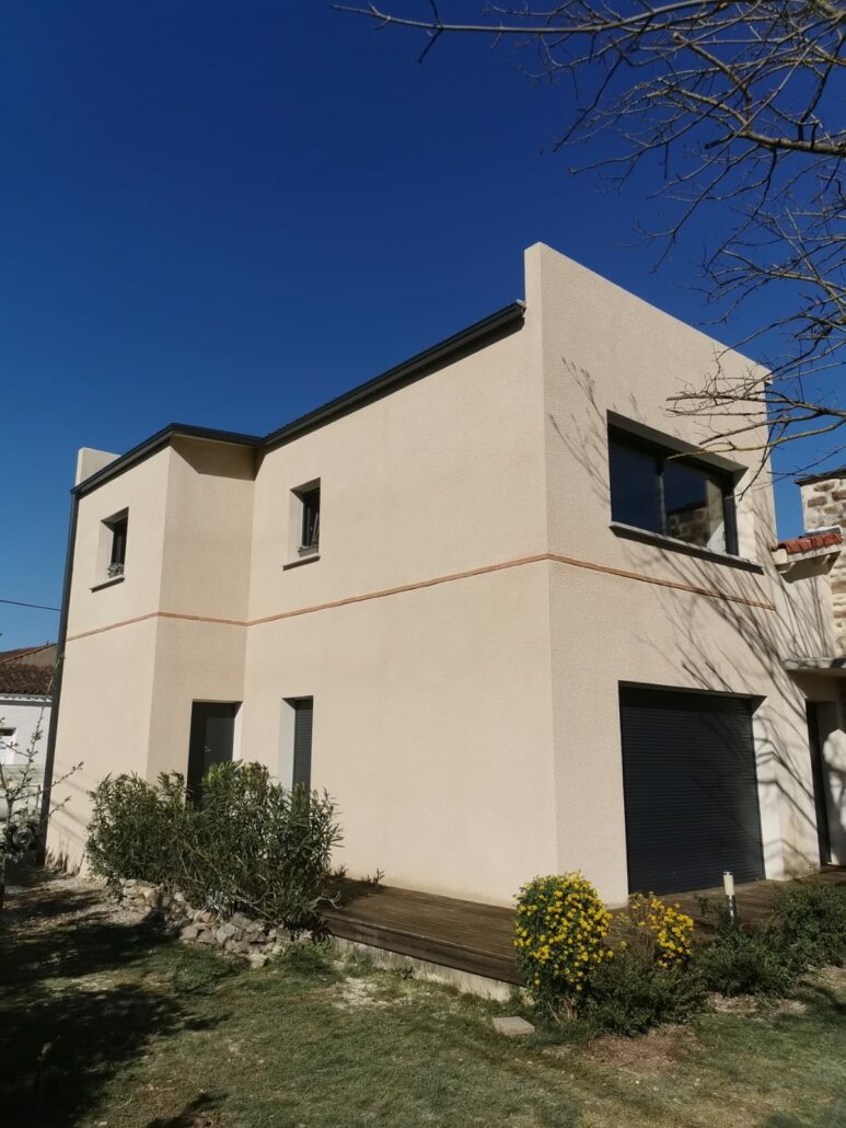 Maison beige clair et menuiserie noire